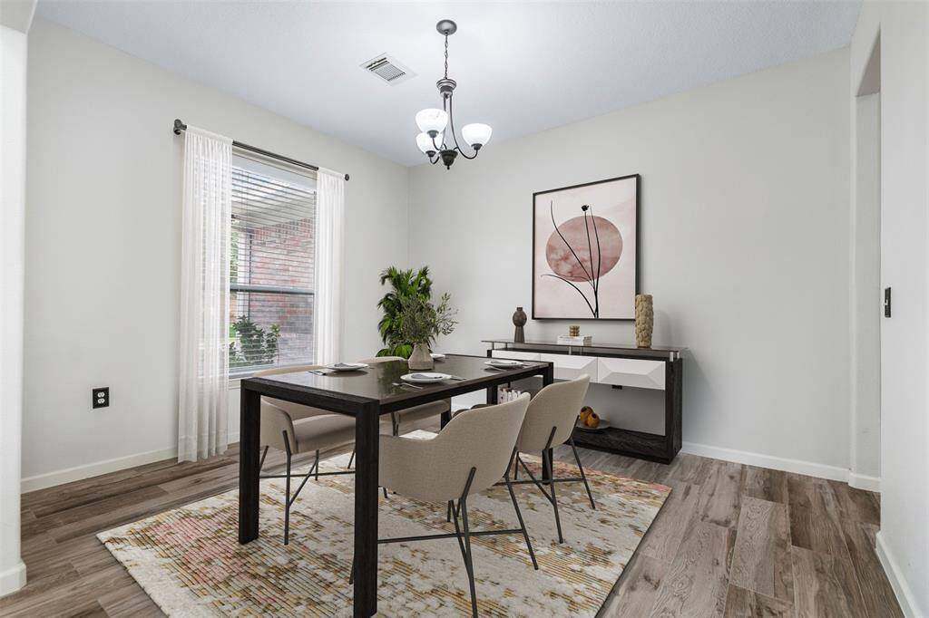 The formal dining room is illuminated by natural light pouring in through a large window, creating a bright and inviting atmosphere. A modern light fixture adds a stylish touch, perfectly complementing the elegant space, making it ideal for both intimate dinners and special gatherings. (This photo is virtually staged)
