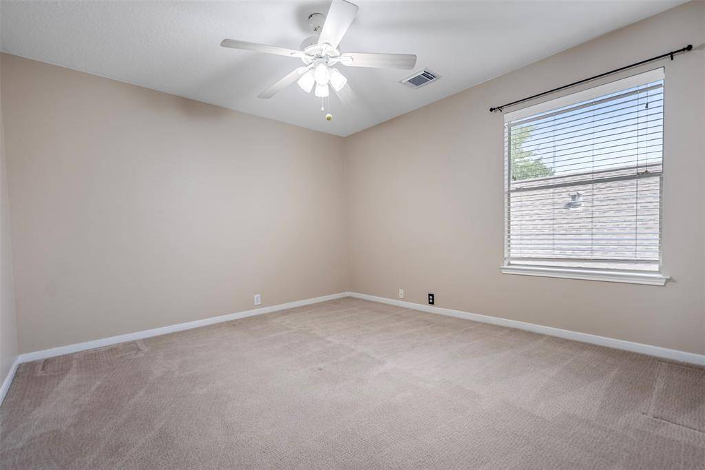 The large third bedroom offers plenty of space, featuring a ceiling fan for added comfort and air circulation. The walls are painted in neutral tones, creating a calm and versatile backdrop that allows for easy personalization, making it an ideal room for a variety of uses.