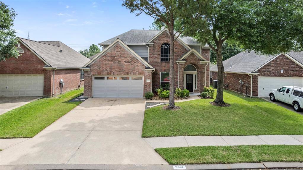 The front of the house boasts an expansive driveway, providing ample parking and a welcoming entrance. Towering mature trees line the property, adding beauty, shade, and a sense of tranquility to the home’s curb appeal, creating a picturesque and inviting first impression.
