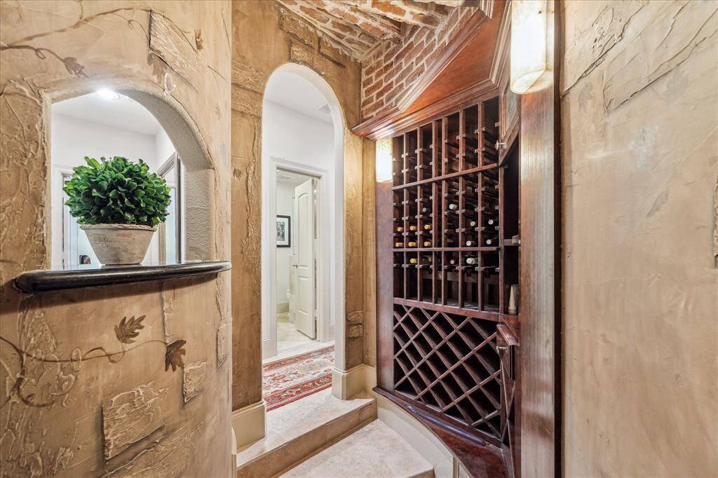 First floor wine bar with custom brick inlays and hand painted vines on the stone siding and plenty of wine bottle storage space.