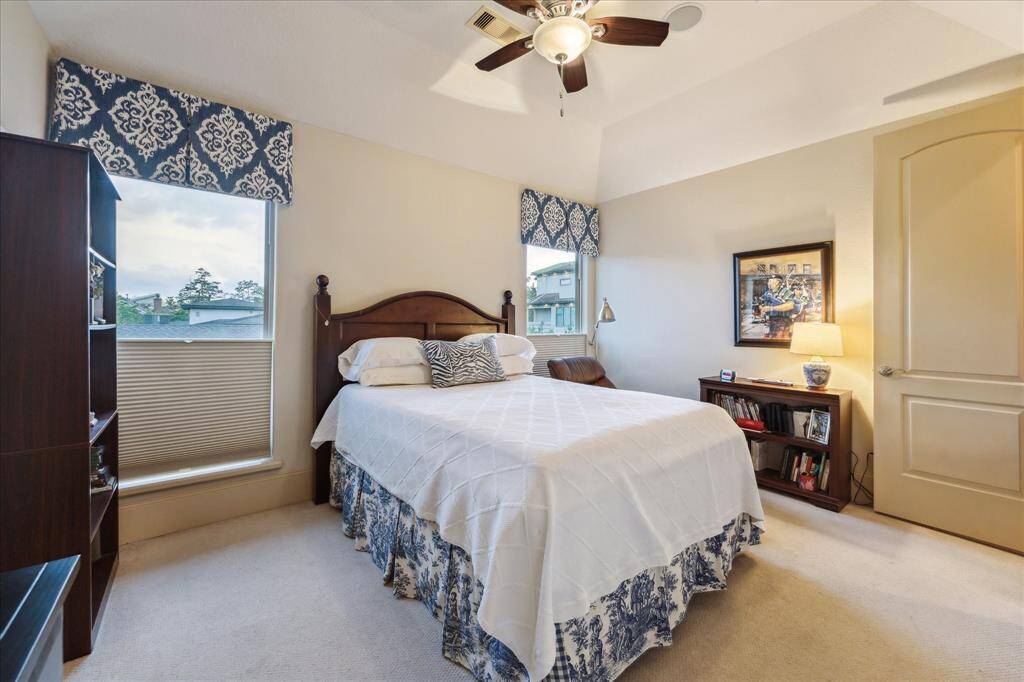 Third level carpeted guest bedroom, generously sized with en-suite tub/ shower bathroom and custom drapes/ window coverings.