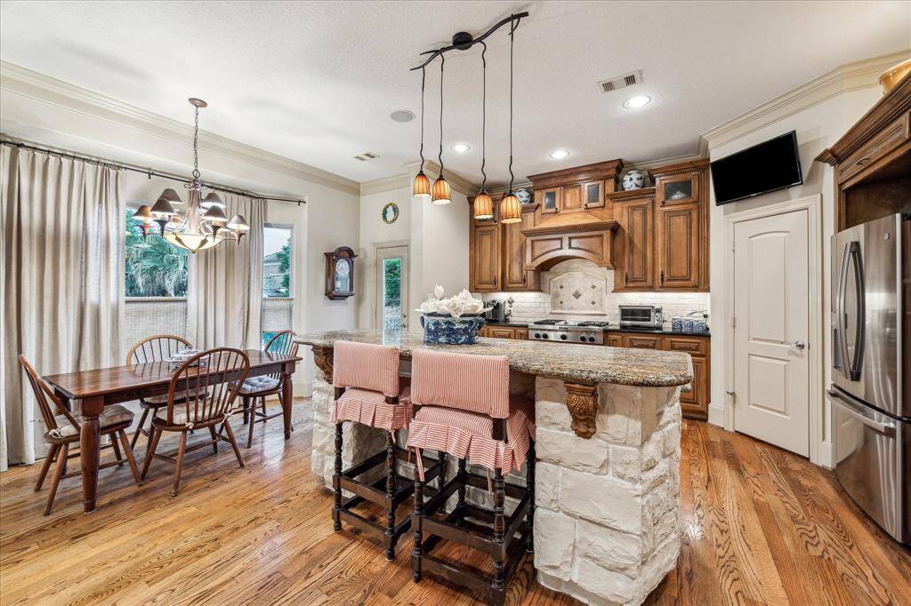 Another view of the kitchen area with room for a breakfast table, and door access to the back area balcony. Note the custom stone work with wood inlays for the kitchen counter .