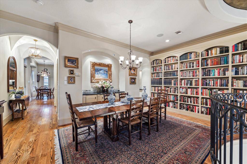 Another view of the spacious dining room with built ins, custom book shelves, and intricate arched passway to the kitchen