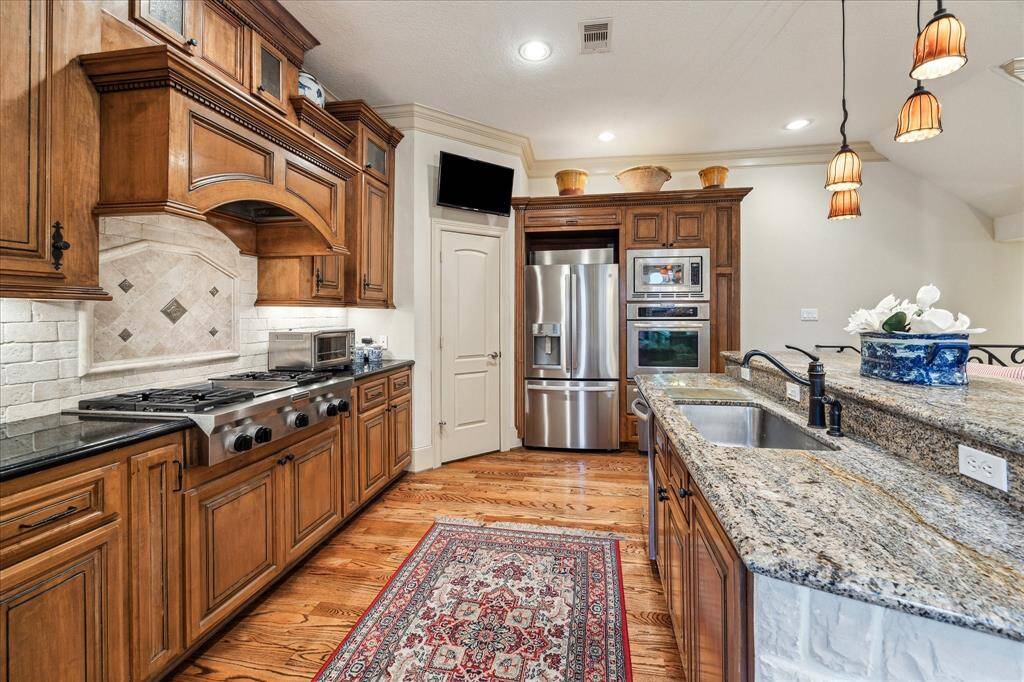 Great open kitchen area with 4 burner/ griddle gas range cooktop, walk in pantry, stainless steel Kitchen Aid appliances(fridge, oven, microwave and warming drawer), granite multi-level prep area and plenty of serving space.