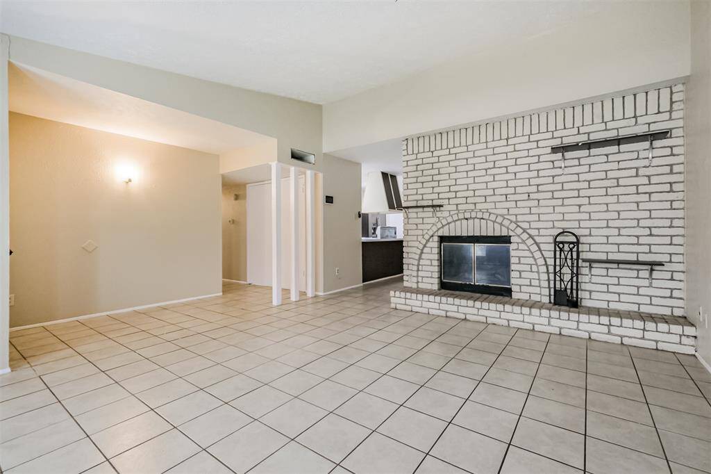 Living area with brick wall with wood burning fireplace