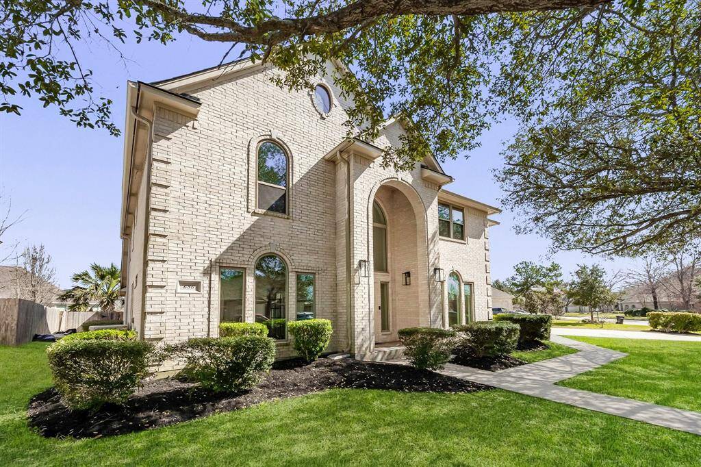 Welcome to your stately two-story home with striking curb appeal, this home features a light-colored brick exterior, elegant arched windows, and meticulous landscaping. The covered entryway and arched double-height portico add grandeur to the facade.