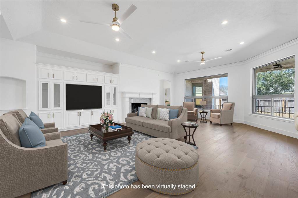 An entertainer’s dream, the layout features custom built-ins, a gas log fireplace, large windows overlooking the backyard, and a seamless connection to the outdoors.