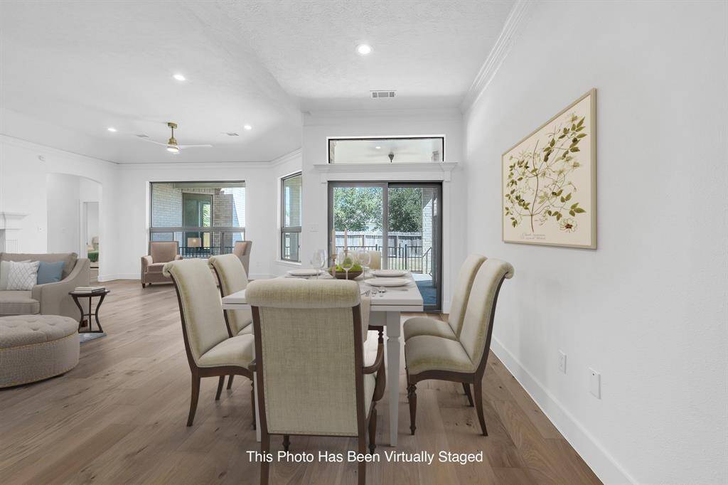This bright and airy breakfast nook offers the perfect place for everyday meals, framed by large windows and sliding glass doors that open to the backyard. Virtually staged to showcase its potential, the space is seamlessly connected to the living and kitchen areas.