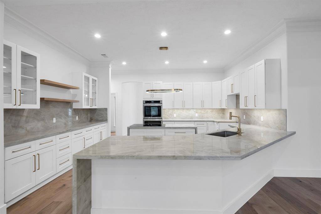 This perspective highlights the exceptional counter space, ample storage, and open shelving ideal for both display and convenience. The wraparound layout flows effortlessly into the living and dining areas.