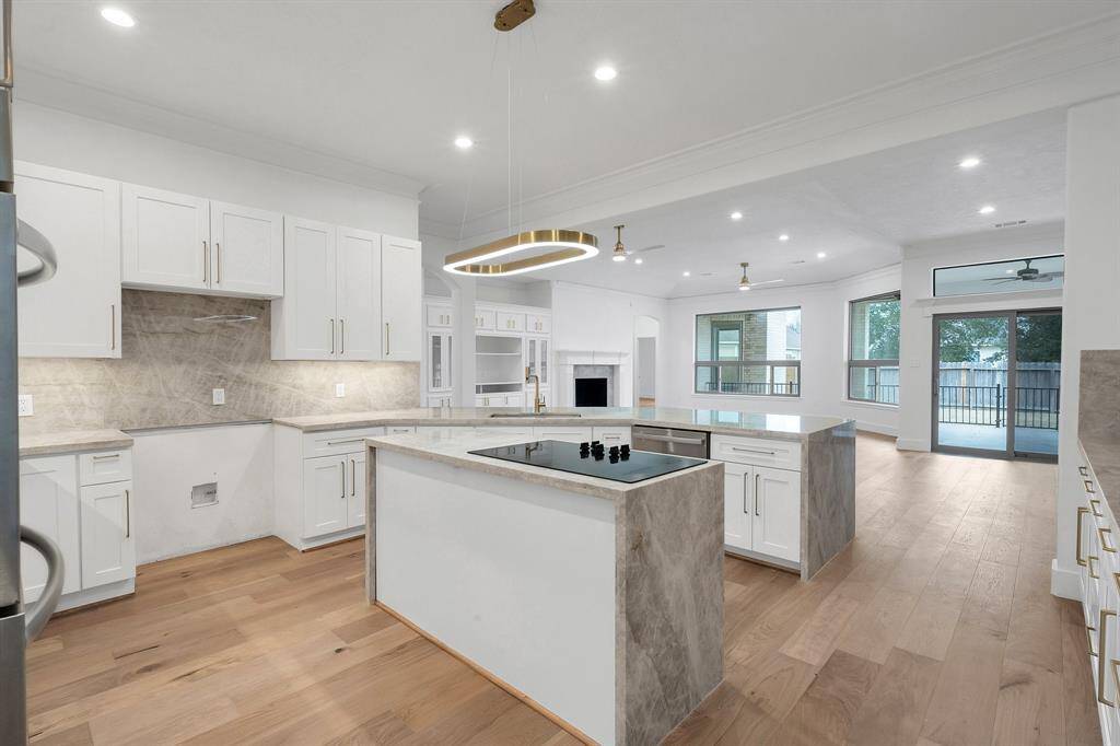 This perspective highlights the exceptional counter space, ample storage, and open shelving ideal for both display and convenience. The wraparound layout flows effortlessly into the living and dining areas.
