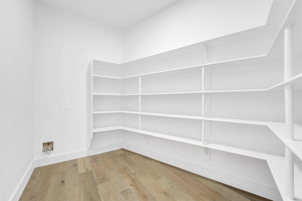 A massive walk-in pantry offers endless storage with wraparound built-in shelving—ideal for stocking essentials, organizing dry goods, or even adding a coffee or wine station.