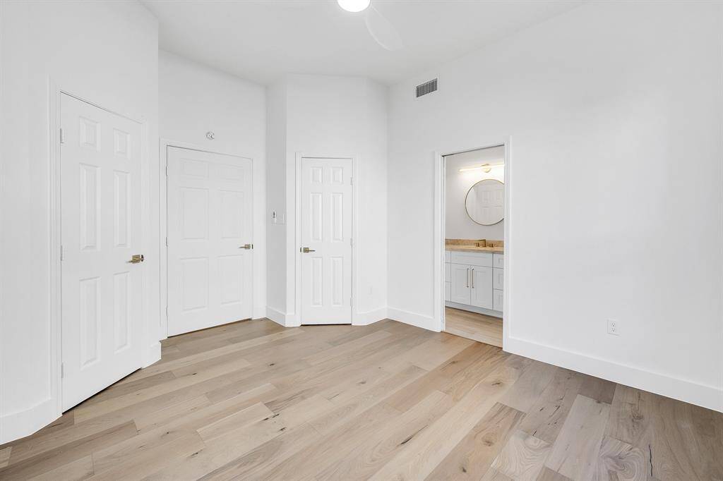 The reverse view of the secondary downstairs bedroom shows its two closets and connection to the full bath.