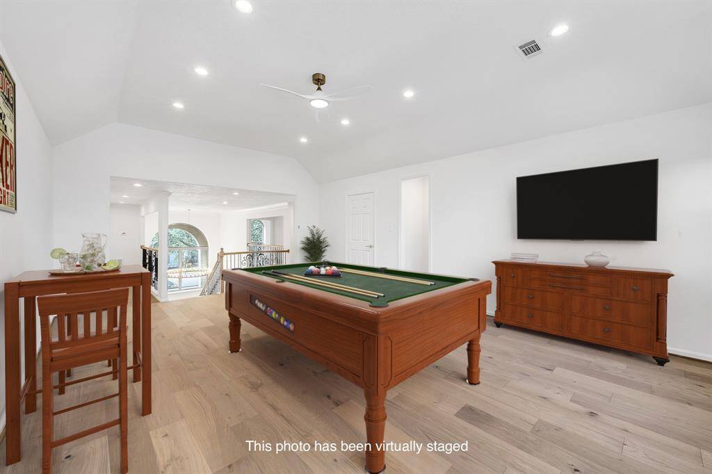 This spacious upstairs game room is virtually staged as a fun and inviting entertainment area ideal for hosting movie nights or game tournaments. Recessed LED lighting and a sleek ceiling fan elevate the space.