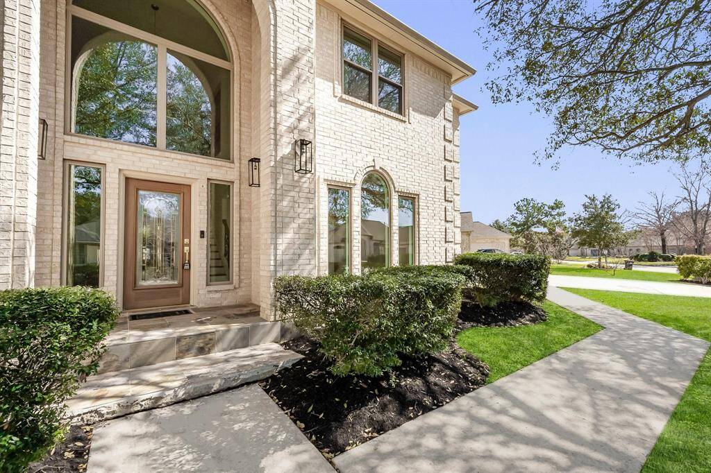 Step into luxury through a decorative glass front door, flanked by sidelights and topped with an arched transom window that floods the foyer with natural light. The elevated porch adds to the home’s distinguished presence.