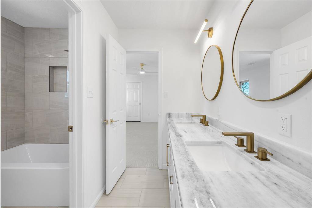Another view of the Jack-and-Jill bath showcases the tiled tub/shower combo with a built-in niche, making it both functional and visually appealing for kids or guests.