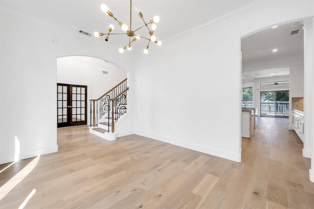 This reverse view of the dining room showcases the seamless flow into the kitchen and living areas, framed by graceful archways.