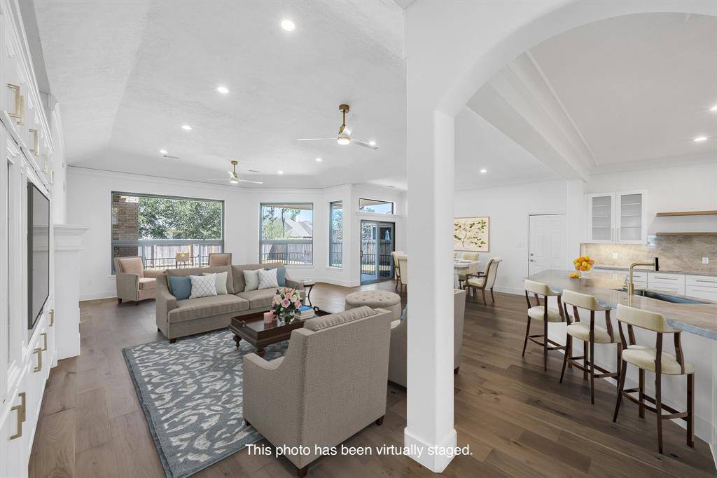 Bright and spacious, the living area is staged and offers open views of the backyard through oversized windows. The space flows seamlessly into the kitchen and breakfast areas.