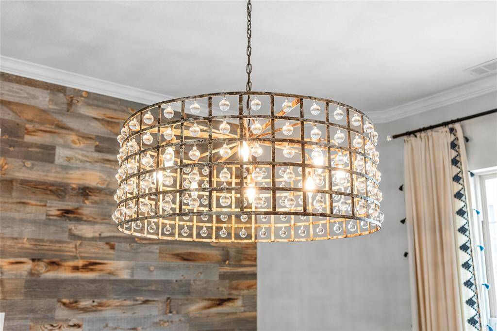 A stunning custom chandelier serves as the centerpiece of the formal dining room, adding a touch of timeless elegance and artistic flair.