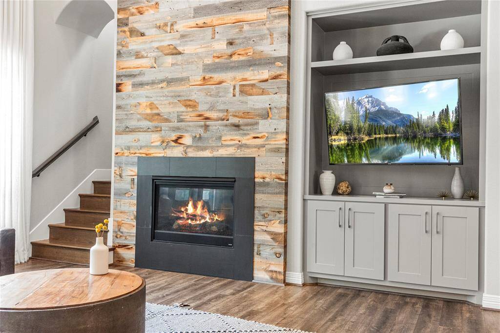 Drawing the line of sight upward, the fireplace acts as a focal point and commands attention. The built-ins provide stylish storage and display space, enhancing the room’s warmth and inviting atmosphere.