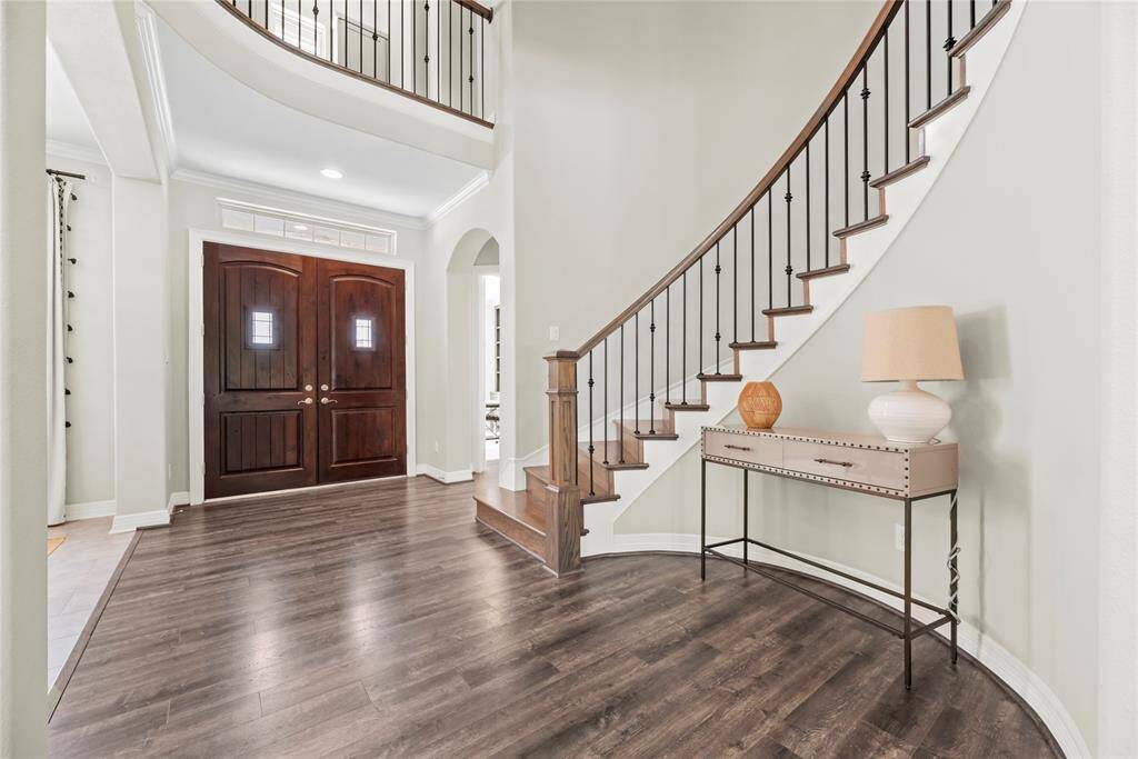 Walking into the home, the entry invites positive attention and welcomes guests in a most impressive fashion. Deep, richly toned wood and wrought iron help create a visually pleasing, curved staircase, highlighting the appreciation for rounded edges and dapper details.