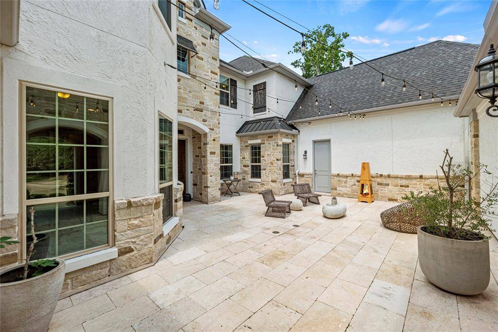 A charming courtyard greets guests at the front of the home, offering a warm and inviting first impression. This thoughtfully designed space leads directly to a private entrance for the guest suite, ensuring comfort and convenience.