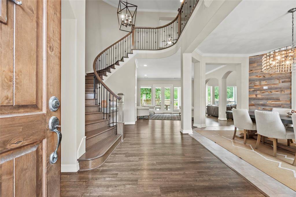 Grand and spectacular, the two-story foyer makes an impression on all your guests! Richly toned LVP wood floors gleam in the presence of luminous natural light, while the above light fixture adds a touch of luxury.