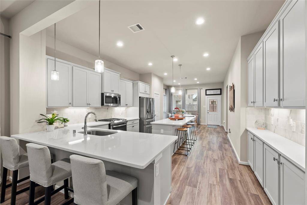 Incredible kitchen features 2 eat-at islands with pendant lighting, under cabinet lighting, stainless steel appliances, gas range, and stunning Quartz countertops.