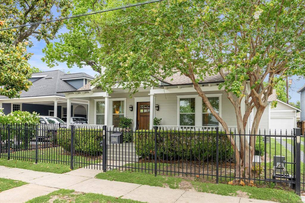 An iron fence with pedestrian gate and automatic driveway gate runs along the front of the property.