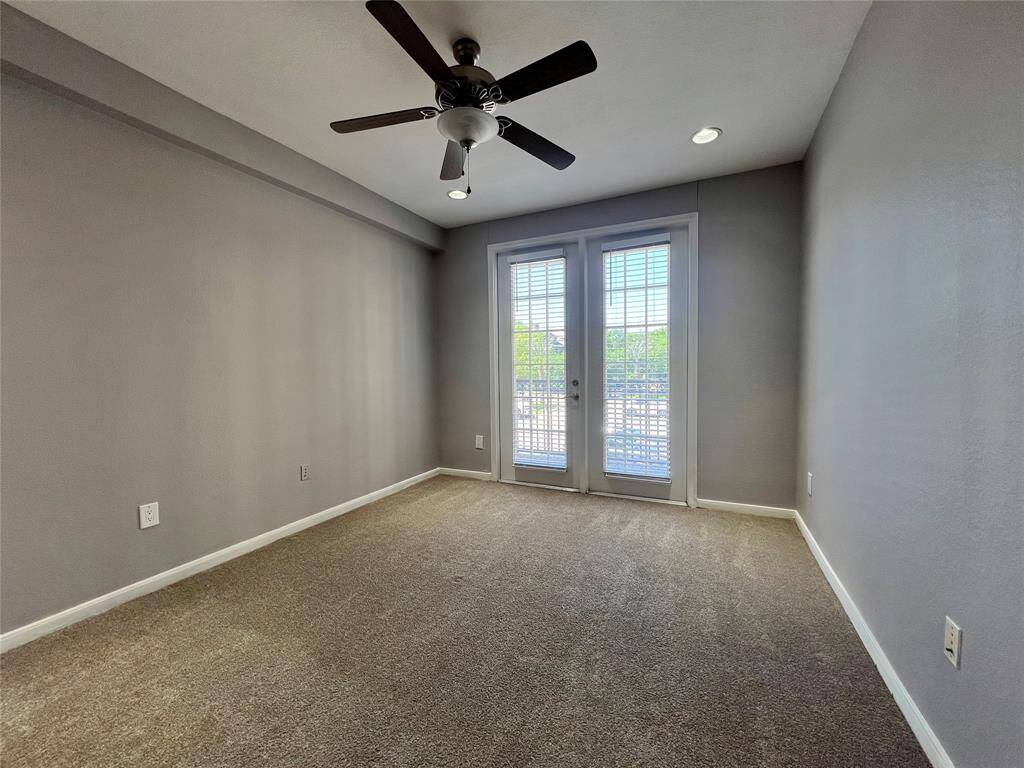 The secondary bedroom has doors that lead out onto the large patio overlooking Kirby Dr. and the pool