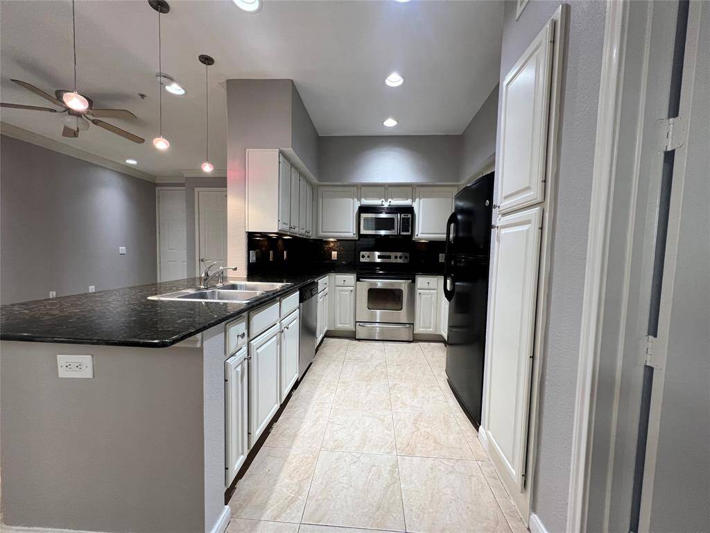 The kitchen has tile flooring, granite countertops and backsplash, stainless appliances and under cabinet lighting.