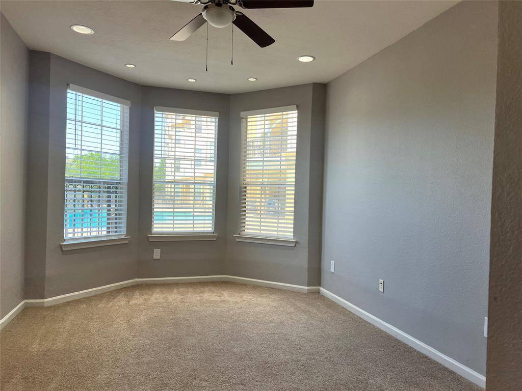 The primary bedroom has a large walk-in closet and bay windows that overlook the pool.