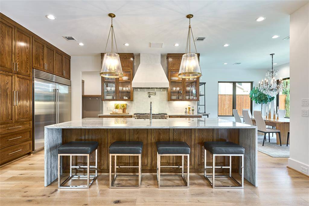 Expansive 10-foot island featuring exquisite white pearl quartzite with waterfall edges, complemented by an 18-inch overhang for additional seating and convenient storage.