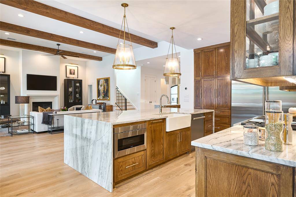 Kitchen island featuring a charming farmhouse-style sink, built-in microwave, and dishwasher for both functionality and style.