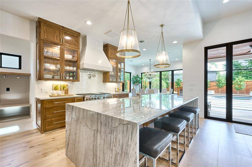 The kitchen seamlessly flows into a well-appointed mudroom and a spacious butler’s pantry, offering additional storage and organization.