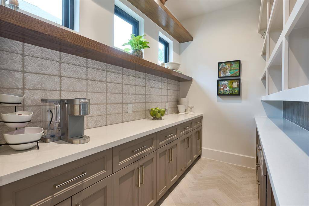 Spacious walk-in butler’s pantry with ample counter space, perfect for storing kitchen appliances and organizing essentials.