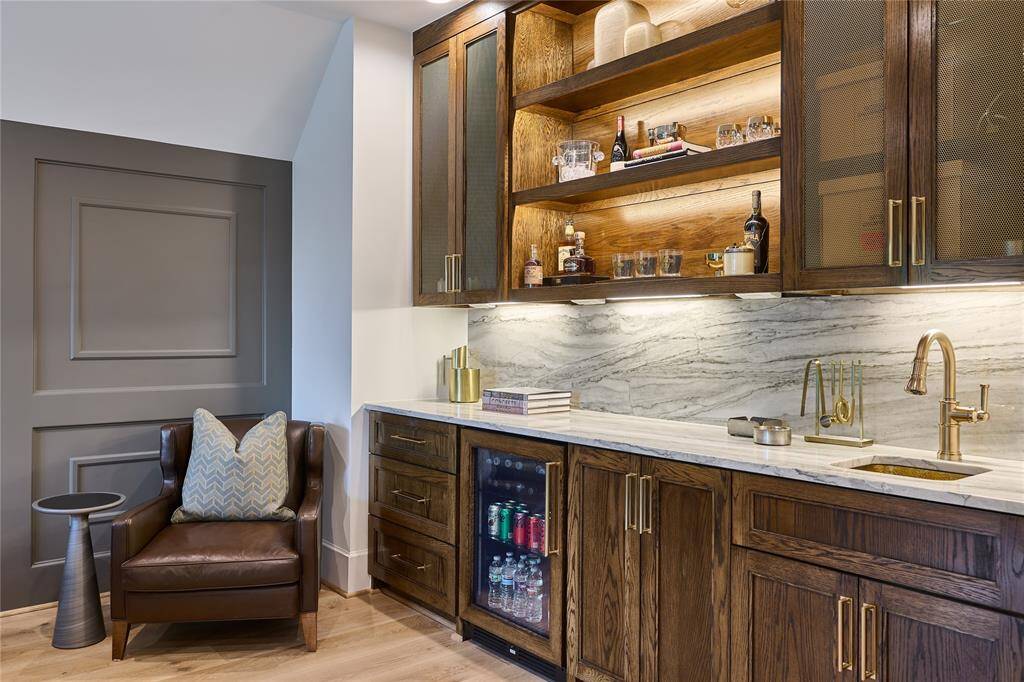 Sophisticated wet bar featuring Oak wood soft-close cabinets, custom LED lighting, and a luxurious solid brass sink, offering both style and functionality.
