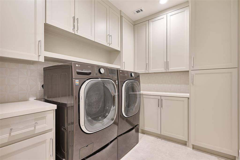 Conveniently located utility room near all the bedrooms, featuring ample cabinet and counter space for maximum organization and efficiency.