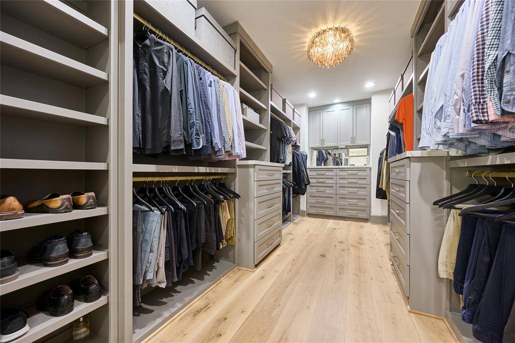 Spacious primary bedroom walk-in closets featuring custom shelving and elegant quartz countertops, providing both organization and luxury.