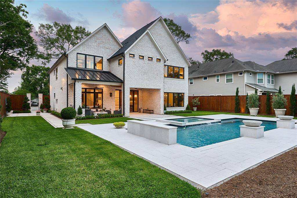 Ample green space surrounds the pool and extends into the side courtyard, providing a perfect balance of outdoor leisure and natural beauty.