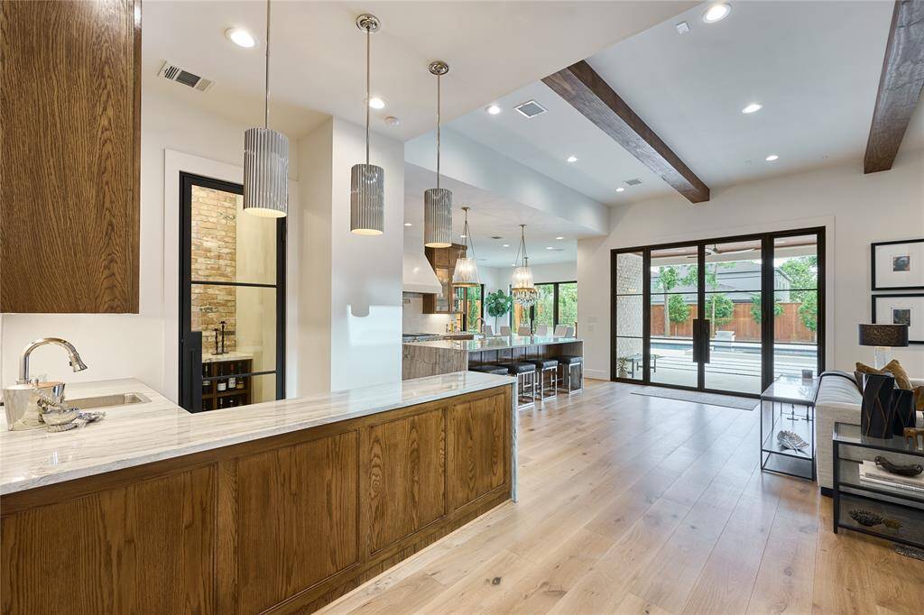 Charming wet bar and beautifully designed wine cellar, ideally located just off the kitchen for seamless entertaining.