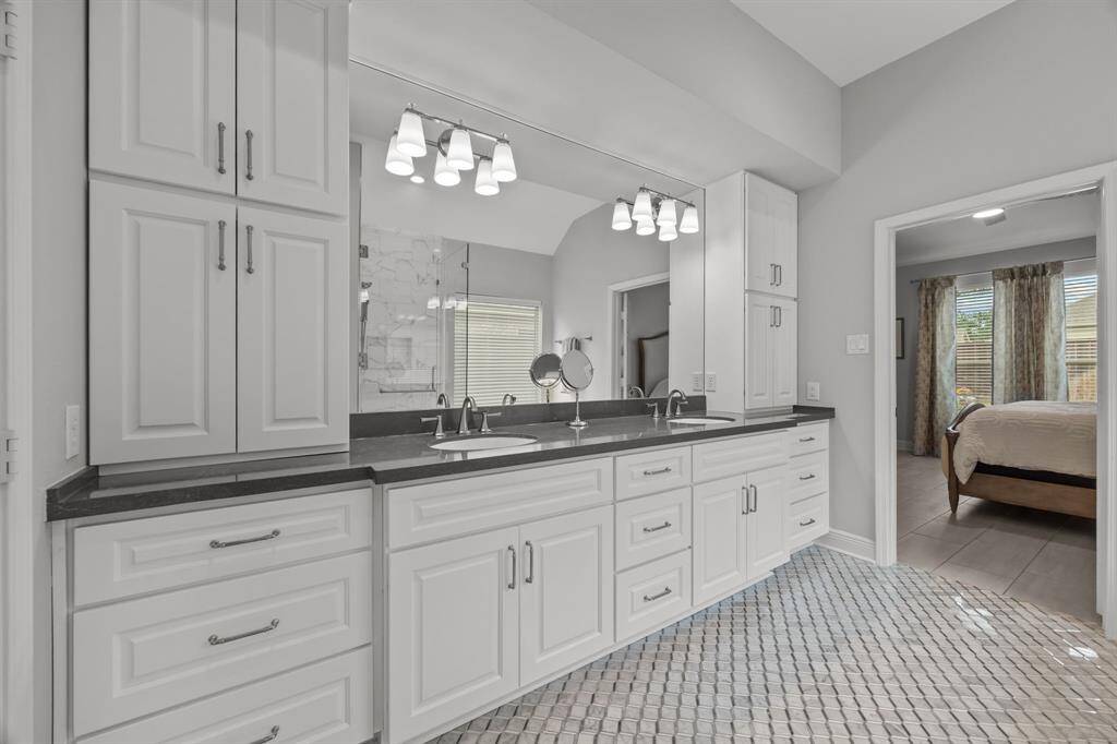 The fully renovated primary bath boasts elegant tile work, a freestanding soaking tub, and a spa-like atmosphere.