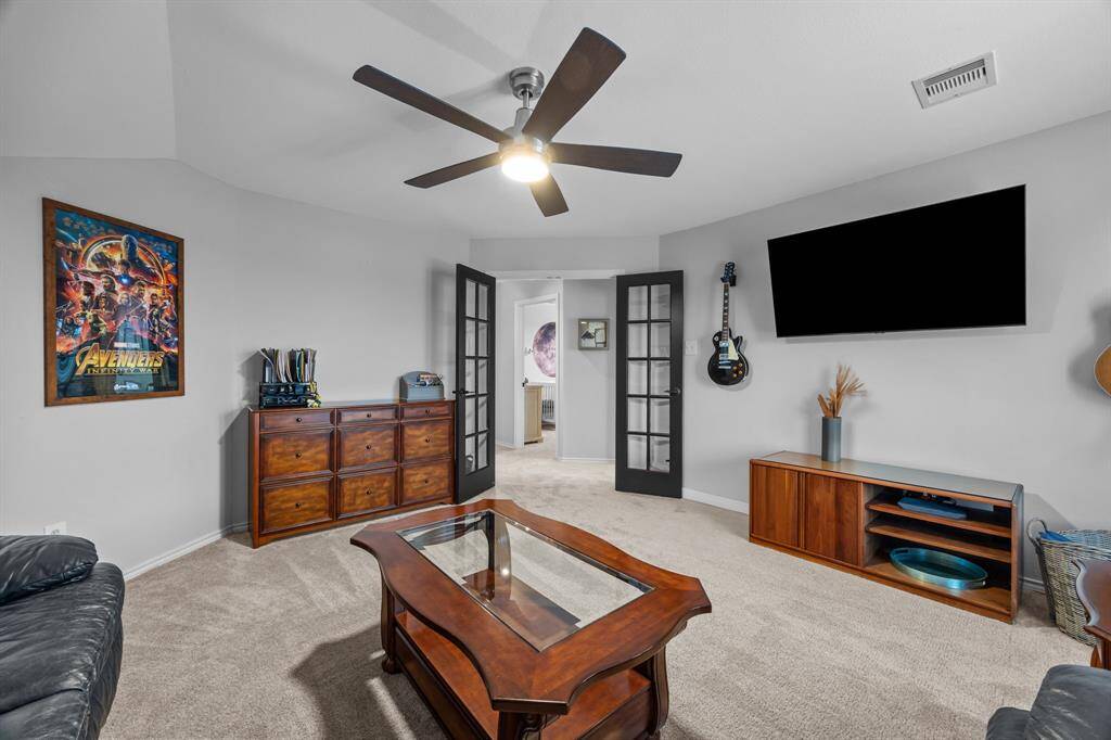 Spacious second-floor game room with elegant French doors, perfect for all your entertainment needs.