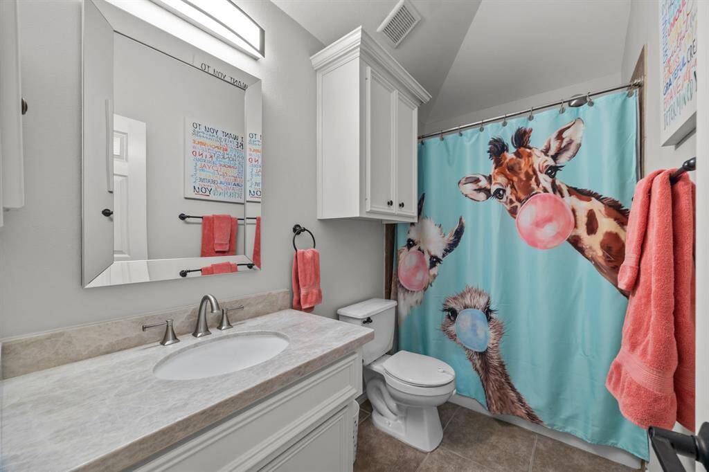 Stylish hall bathroom with a tub/shower combo and elegant tile flooring.