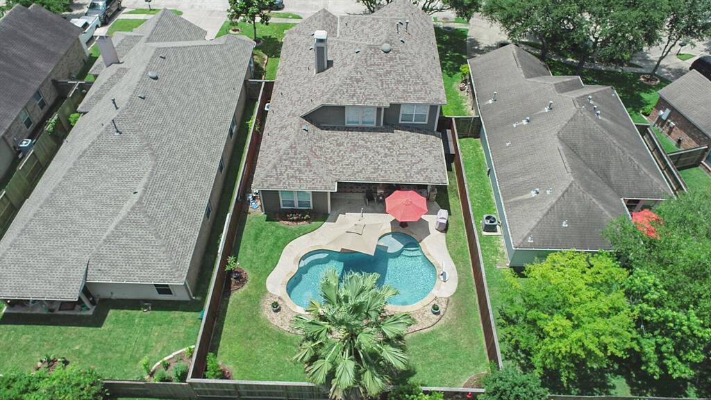 A captivating aerial view showcases this home's inviting backyard oasis, complete with a sparkling pool and lush landscaping.