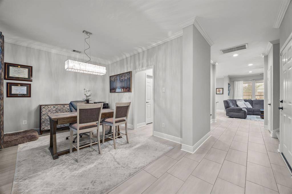 Elegant foyer with stunning tile flooring, leading to an open dining area connected to the kitchen.