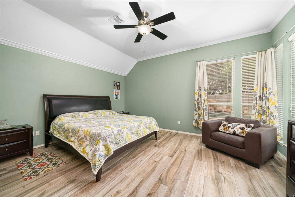 Luxurious Primary Retreat Tucked away at the rear of the home for ultimate privacy, this spacious primary bedroom is a true oasis. An entire corner of floor-to-ceiling windows bathes the room in natural light while offering serene view of the outdoor oasis. The soaring ceilings with elegant crown molding create an airy, upscale ambiance, complemented by the modern ceramic tile flooring that blends beauty with practicality.