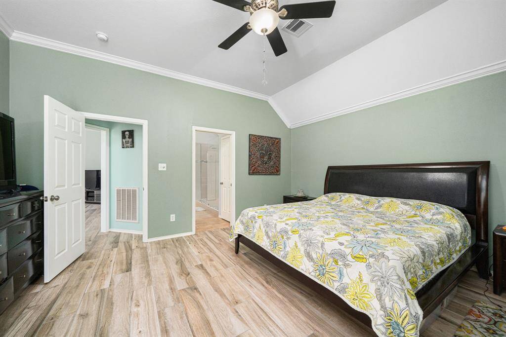 Spacious primary bedroom with soaring ceilings and elegant crown molding create an airy, upscale ambiance, complemented by the modern ceramic flooring. Your ensuite includes a well-appointed bathroom and an expansive walk-in closet, providing both comfort and convenience.