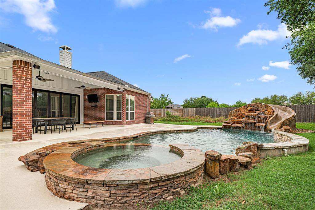 Your Private Resort Awaits in This Stunning Outdoor Oasis. The crown jewel of this property is its breathtaking backyard retreat, designed for ultimate relaxation and entertainment. The expansive covered patio offers year-round enjoyment. At the heart of it all lies your custom pool paradise, featuring: beach entry for easy access, Cascading waterfalls and exciting slide, Integrated hot tub for soothing soaks, Sprawling green spaces that enhance privacy.