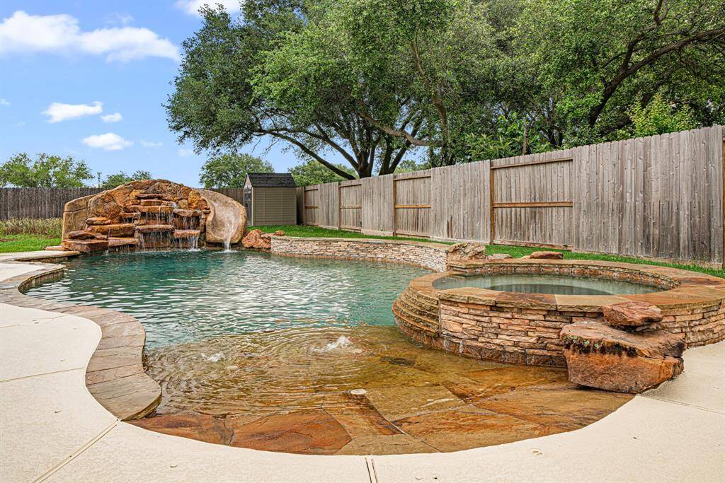 Custom pool paradise, featuring: beach entry for easy access, Cascading waterfalls and exciting slide, Integrated hot tub for soothing soaks.