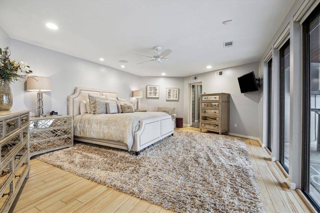The private, primary bedroom is spacious and has bamboo floors and overlooks the outdoor area and pool.